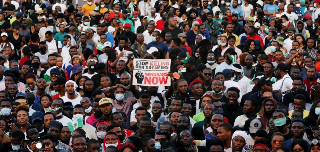People gathered in large numbers with a placard displaying End SARS